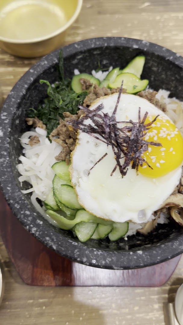 Un bibimbap avec œuf, légumes, riz et accompagnements coréens