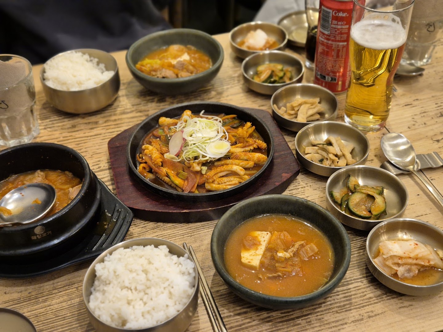 Une table coréenne avec des poêlons, des soupes, du riz et des accompagnements